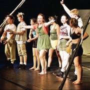 artist in residence performers standing on stage waving to their audience